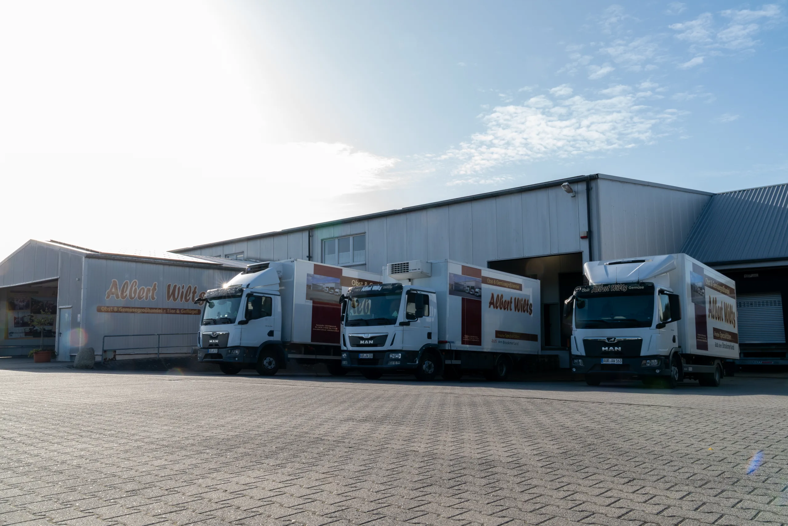 Drei Kühl-Lkw des Albert-Wilts-Fuhrparks vor der Lagerhalle in Upgant-Schott